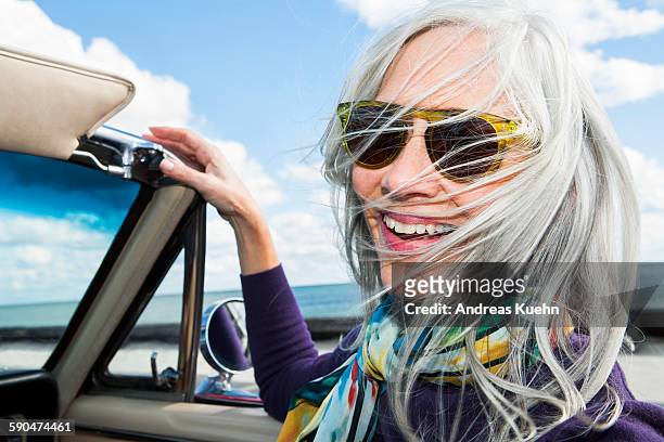 woman with a big smile in a convertibel car. - einzelne frau über 40 stock-fotos und bilder