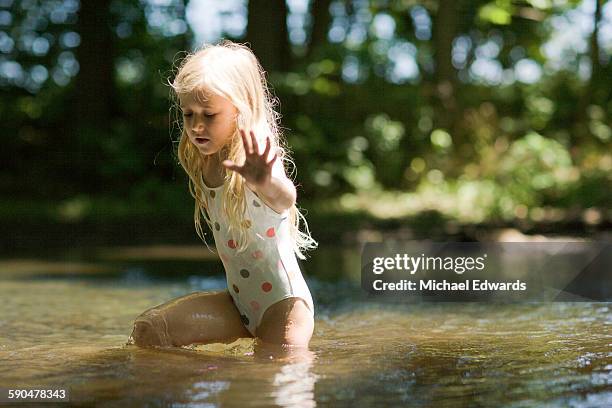 young girl playing in river - tween girl swimsuit stock-fotos und bilder