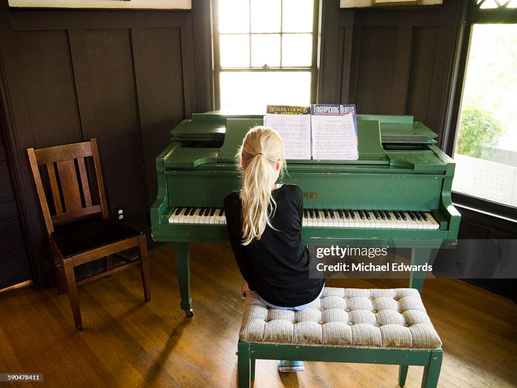 Young blonde girl playing piano