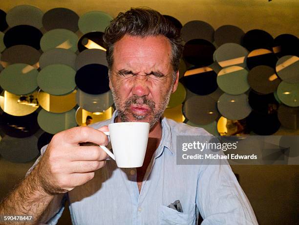 man tasting bitter coffee - offensive stock-fotos und bilder