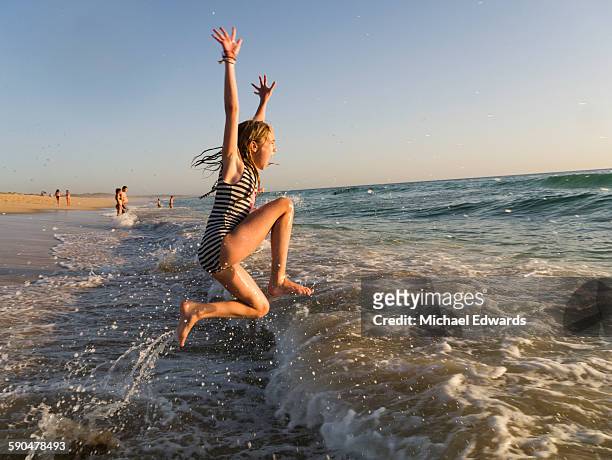 girl jumps into surf