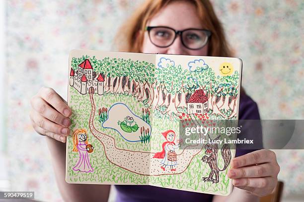 studio portrait of young artist showing her work - woman frog hand stockfoto's en -beelden