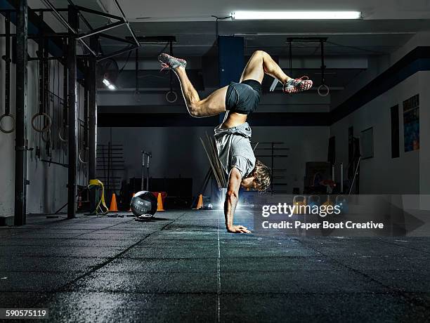 side view of a man doing handstand in the gym - handstand stock pictures, royalty-free photos & images