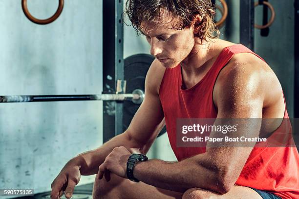 athlete taking a break from workout, checking time - hiit stock pictures, royalty-free photos & images