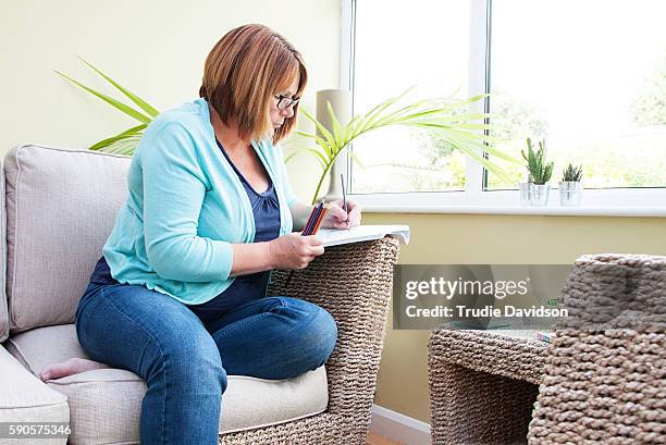 adult coloring books - brief - left hand holding pencil stock pictures, royalty-free photos & images