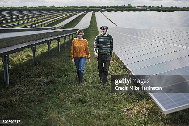 young farmers walking through solar farm - repetition industry stock pictures, royalty-free photos & images