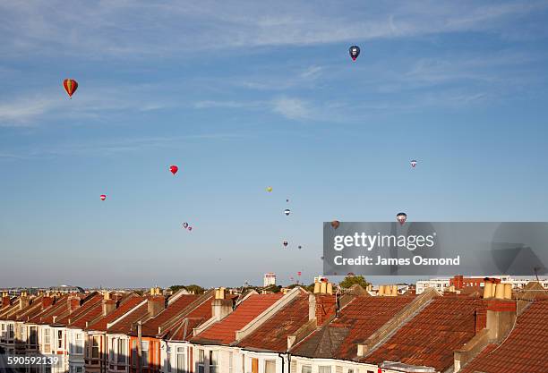 mass ascent of hot air balloons over rooftops - bristol hot air ballooning stock-fotos und bilder