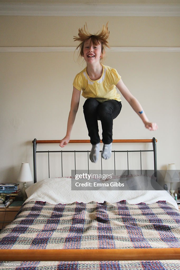 Child jumping on parents bed