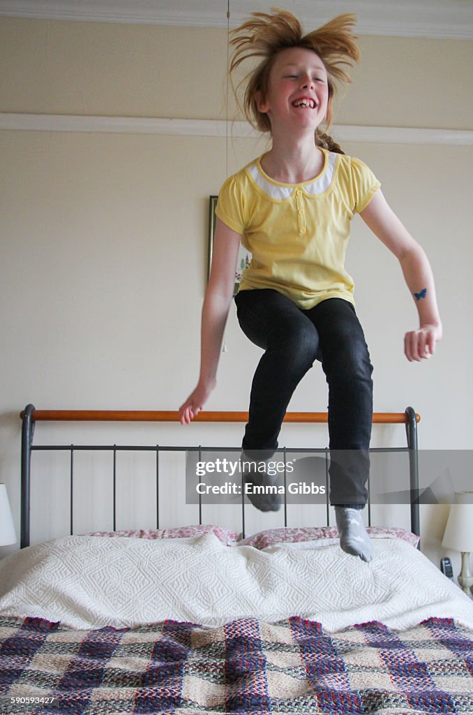Child jumping on parents bed