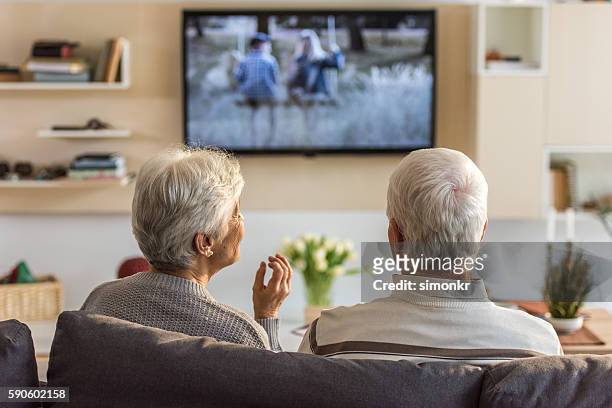 senior-paar schaut fernsehsendung - television show stock-fotos und bilder
