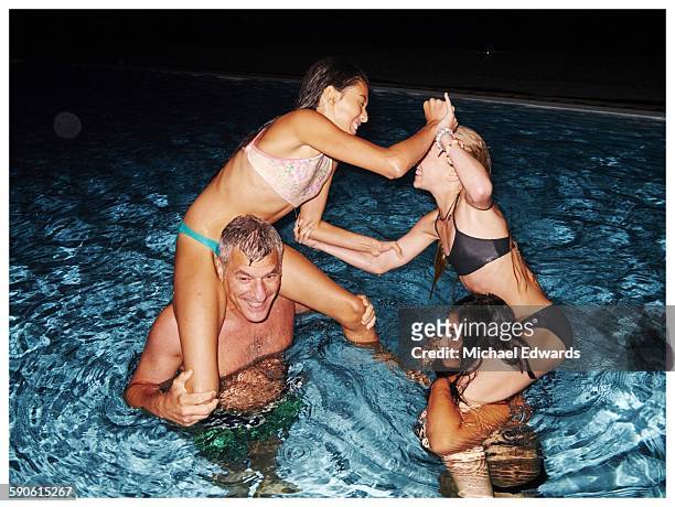 family playing in pool at night - preteen girl no shirt stock pictures, royalty-free photos & images
