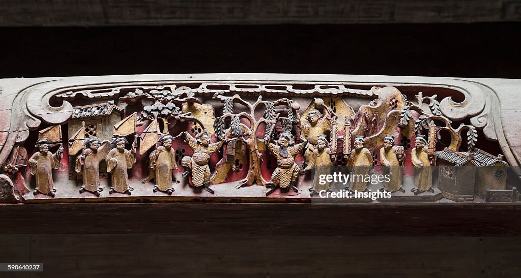 Wooden beam decorated with carvings of scenes from Qing dynasty life in Chengzhi Hall.