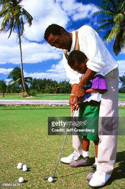 Bahamas, Nassau, Cable Beach, Father Teaching Son How To Swing Golf Club.