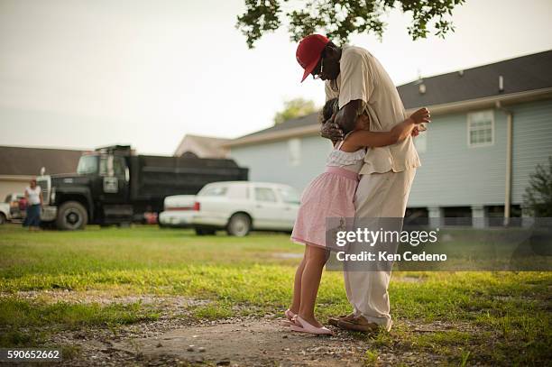 Pastor Ernest Dison of St. Paul Church of God in Christ hugs a little girl after preaching at a tent revival in the lower 9th ward of New Orleans...