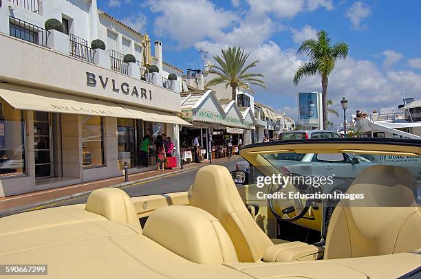 Luxury car and shops at the exclusive yacht harbor of Puerto Banus, Marbella, Costa del Sol, Malaga province, Andalusia, Spain.