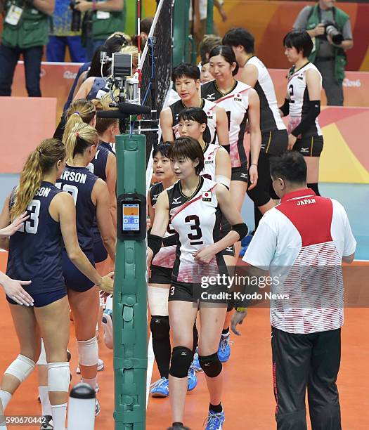 And Japanese players shake hands after their women's volleyball quarterfinal match at the Rio de Janeiro Olympics on Aug. 16, 2016. The United States...