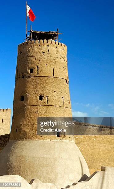 Flag of Dubai on the tower of the Al Fahidi Fort in Dubai, United Arab Emirates, which houses the Dubai Museum. Traditional architecture from the...