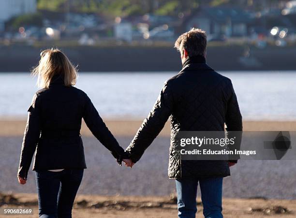 Middle aged couple holding hands, Devon, UK.