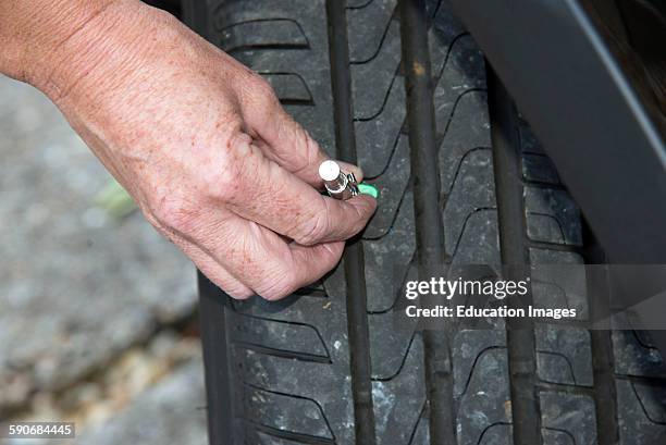 Woman using tire depth gauge.