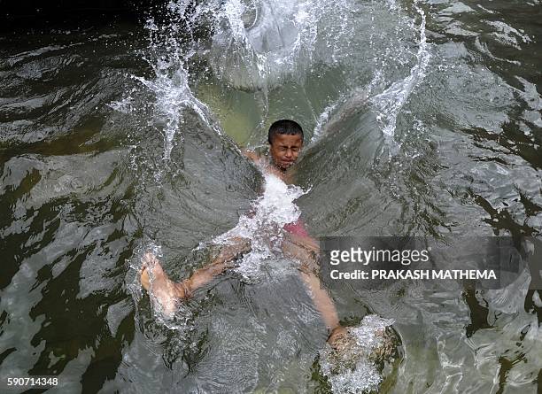Nepalese boy splashes in a pool of water collected from a stone spout near the Patan Durbar Square in Lalitpur, about five kilometers south-east of...