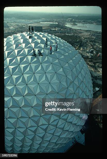 During the final stages of construction, workers bolt aluminum panels onto the frame of Spaceship Earth, the 180-foot-high geosphere that is the...