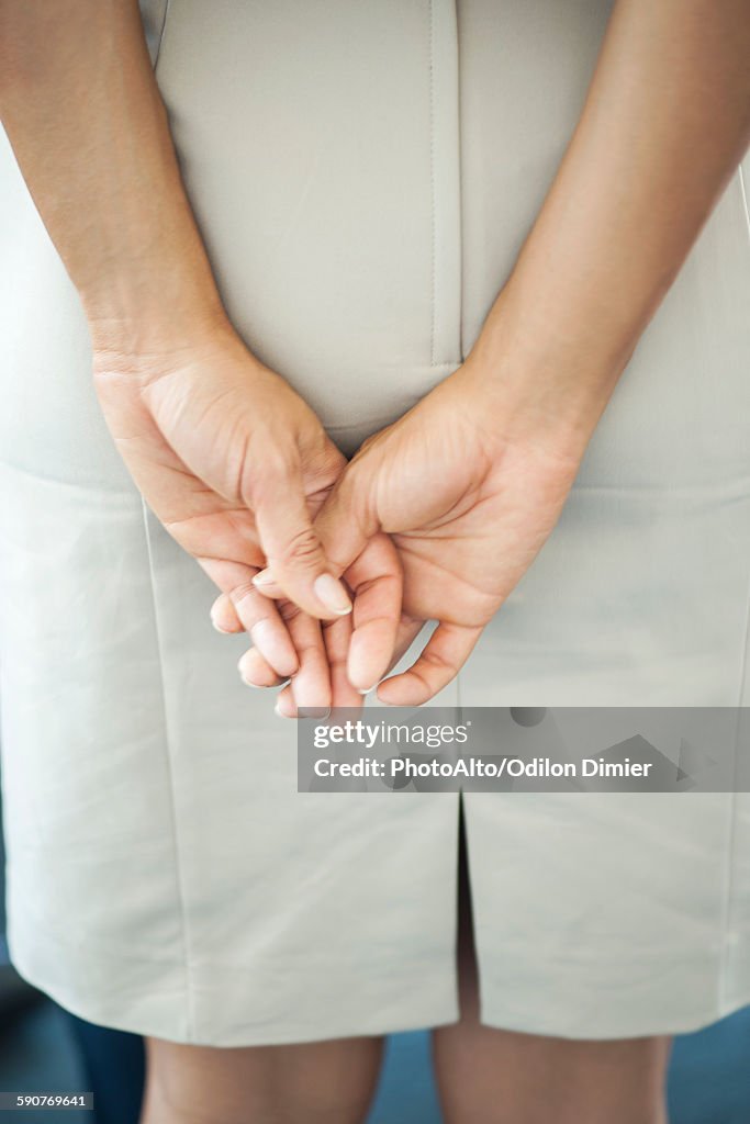 Womans clasped hands, rear view
