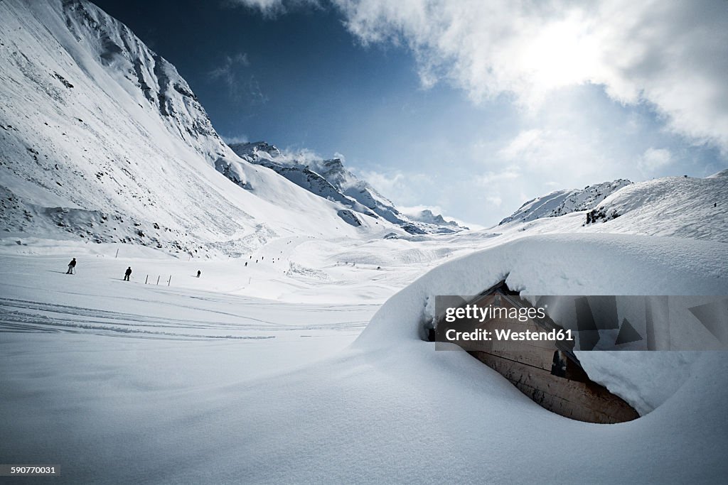 Austria, Tyrol, Ischgl, snow-capped hut in winter landscape