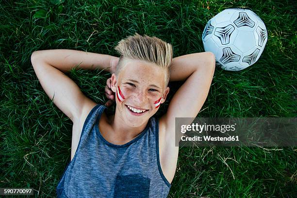 austria, vienna, portrait of smiling teenage boy with national colors painted on his cheeks - austrian culture stock pictures, royalty-free photos & images