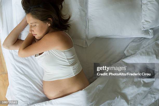 pregnant woman sleeping in bed alone - moments daily life from above imagens e fotografias de stock