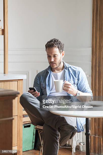 man sending text message during coffee break - smart phone on table stock pictures, royalty-free photos & images
