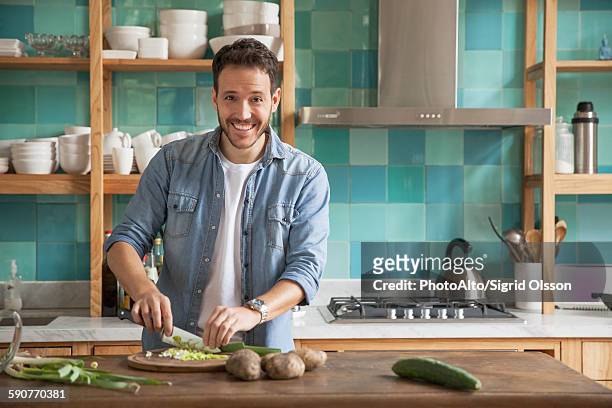 man cutting up ingredients in kitchen, portrait - kitchen cooking imagens e fotografias de stock