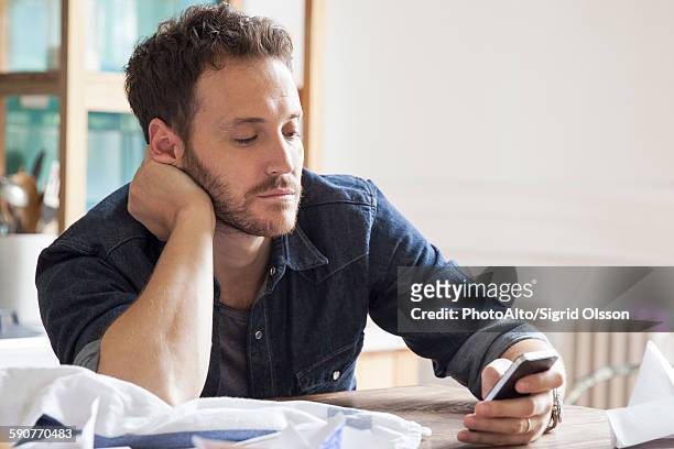 man at home using smartphone - boredom man stock pictures, royalty-free photos & images