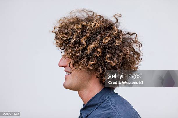 profile of smiling man with curly hair - haare mann stock-fotos und bilder