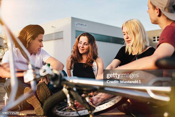 happy friends sitting together outdoors - hannover stock-fotos und bilder