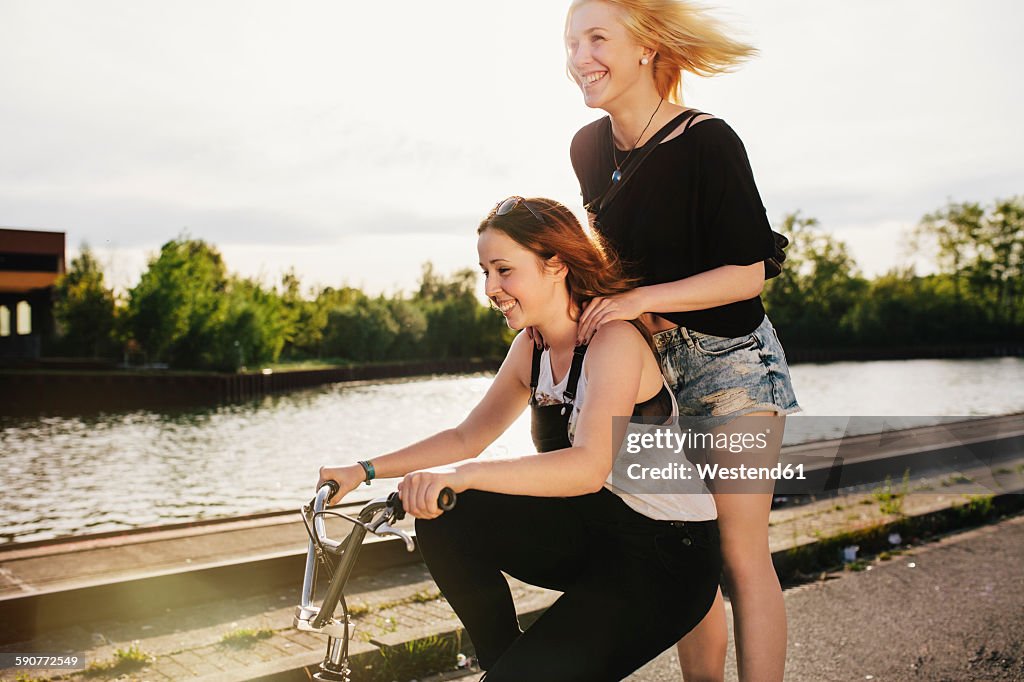 Two friends riding BMX bicycle together