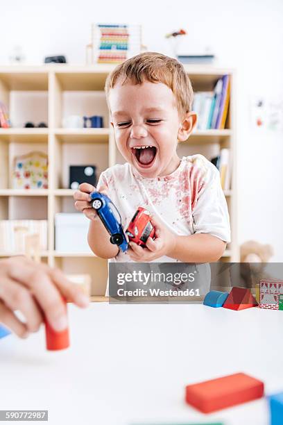 portrait of laughing little boy playing with toy cars - toy cars photos et images de collection