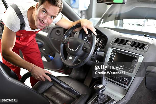 car cleaning, man hoovering car interior - clean car dealership stock pictures, royalty-free photos & images