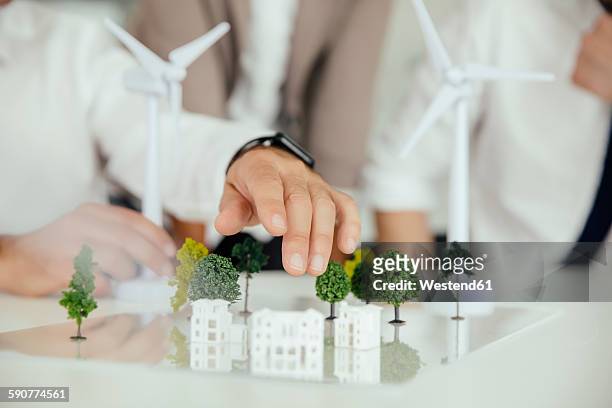 close-up of business people wind turbine model and houses on conference table - architectural model stockfoto's en -beelden