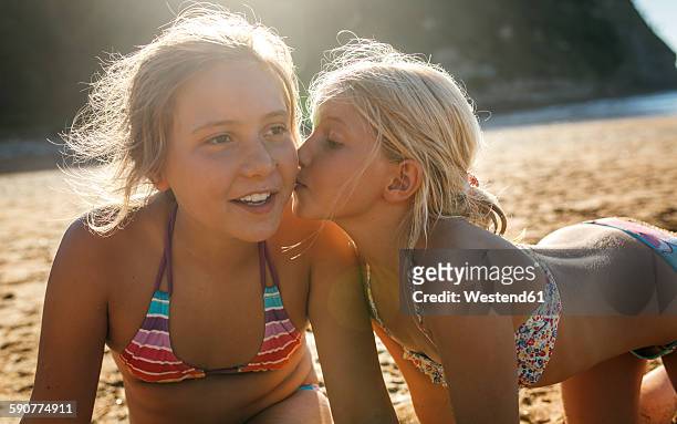 two sisters having fun together on the beach - preteen swimwear bildbanksfoton och bilder