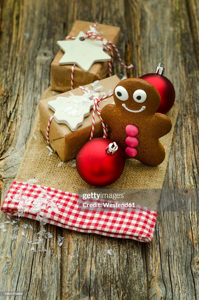 Christmas present, gingerbread man and two red Christmas baubles