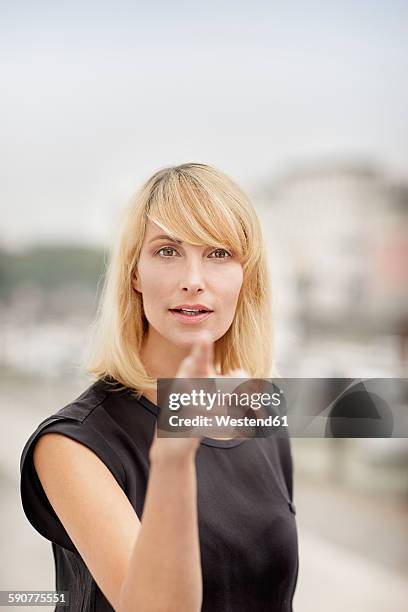 portrait of blond woman pointing on viewer - designer photos et images de collection