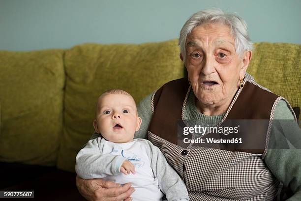 old woman and her great-grandson sitting on the couch - great grandmother imagens e fotografias de stock