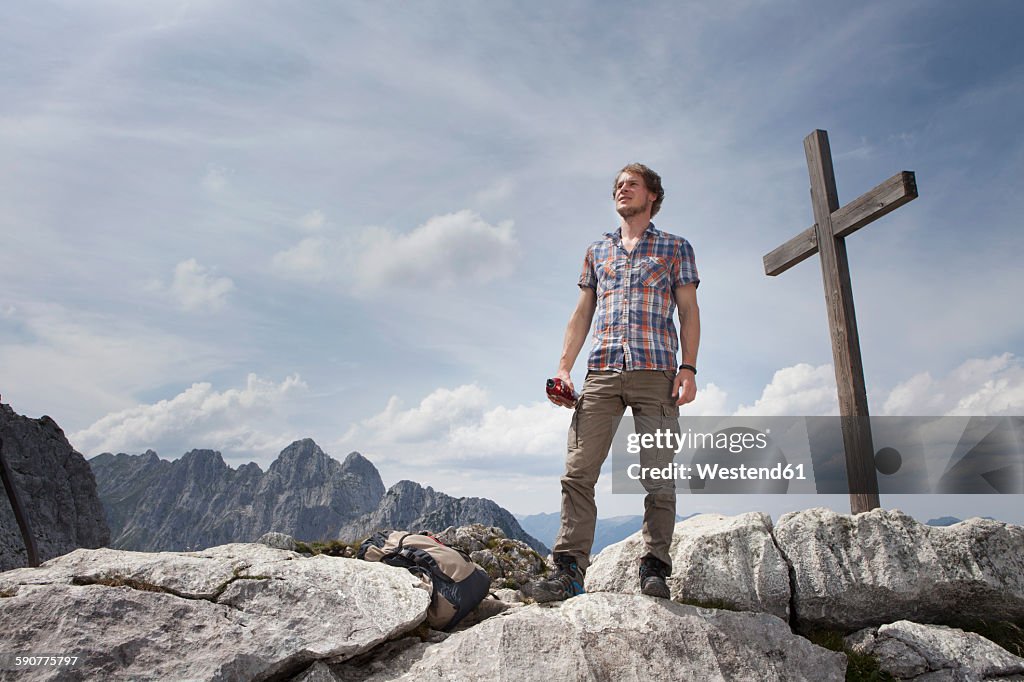 Germany, Bavaria, Osterfelderkopf, man standing at summit cross