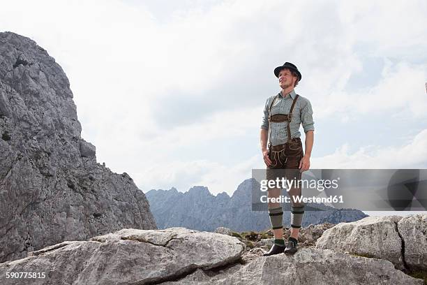 germany, bavaria, osterfelderkopf, man in traditional clothes standing in mountain landscape - beieren stockfoto's en -beelden