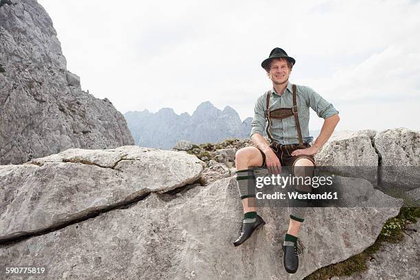 germany, bavaria, osterfelderkopf, man in traditional clothes sitting in mountain landscape - 民族衣装 ストックフォトと画像