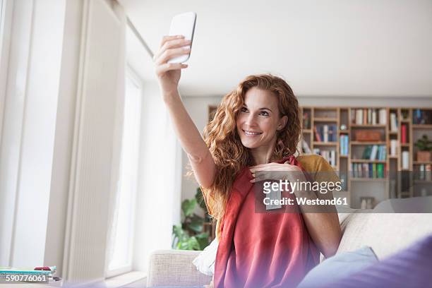 smiling woman at home taking a selfie with new garment - clothing label stock pictures, royalty-free photos & images