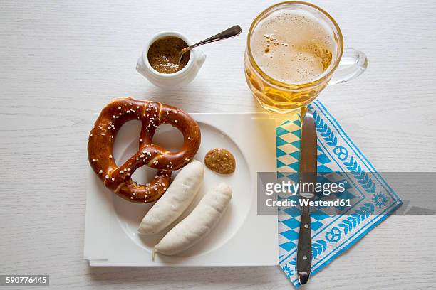sausage with preztel on plate and beer mug, sweet mustard, knife and napkin - bavaria beer stock pictures, royalty-free photos & images