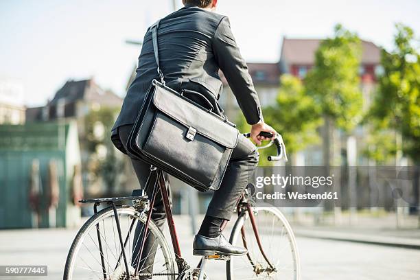 young businessman riding bicycle - green suit stock-fotos und bilder