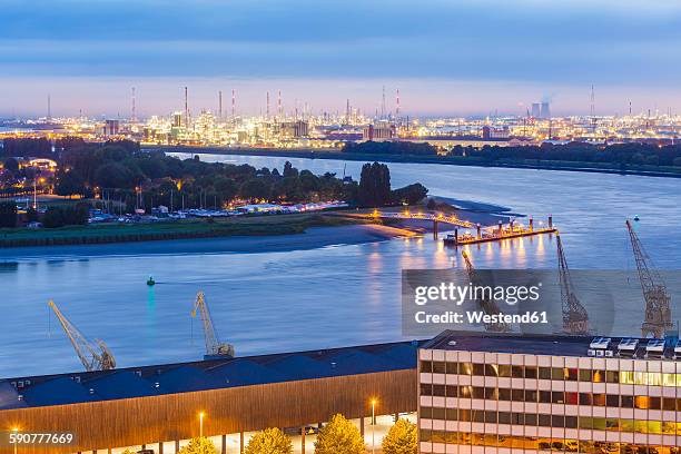 belgium, flanders, antwerp, view to dock area with industrial area at scheidt river in the evening - antwerpen stockfoto's en -beelden