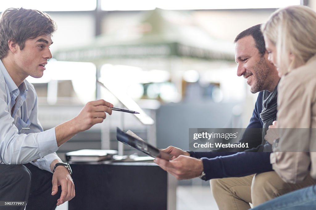 Car dealer talking to couple